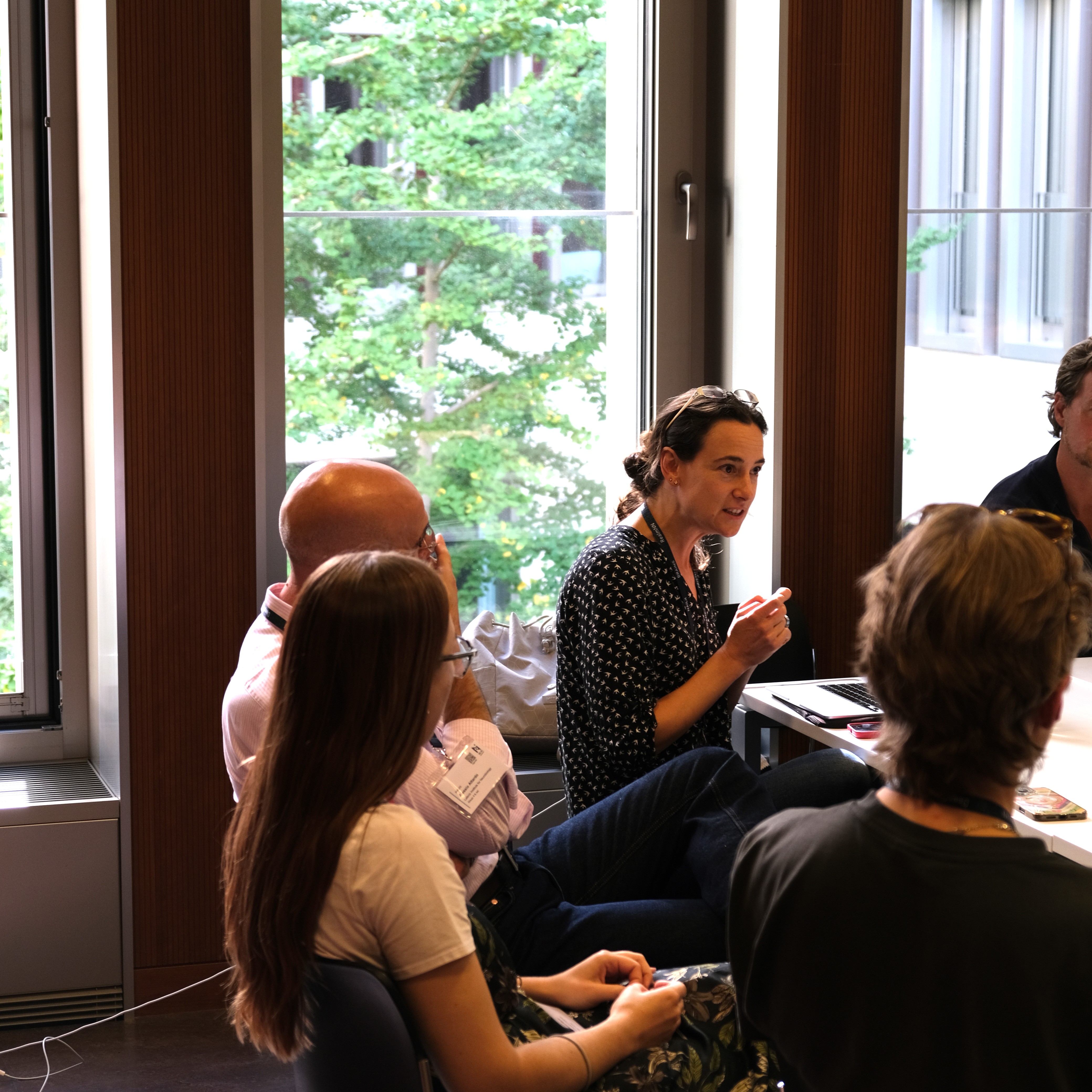 Small group conversation by a window during a break